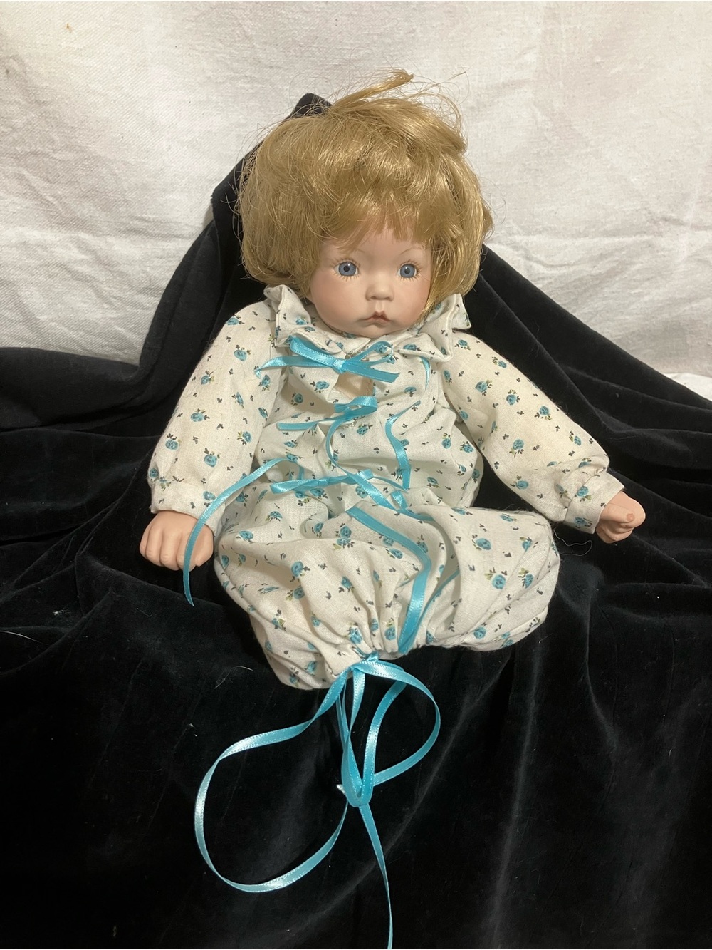 Blonde Baby Doll in White Floral Outfit with Blue Ribbon